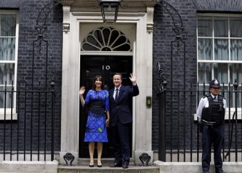Britain's Prime Minister David Cameron and his wife Samantha wave from the steps of 10 Downing Street in London Friday, May 8, 2015 after meeting Britain's Queen Elizabeth II where he informed her  that he has enough support to form a government.  The Conservative Party swept to power Friday in Britain's Parliamentary elections winning an unexpected majority. (AP Photo/Kirsty Wigglesworth )