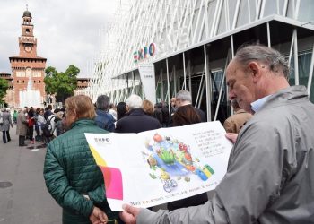 Un uomo legge un volantino dell'Expo mentre è in in fila alla biglietteria  allestia all'Expo Gare in piazza Cairoli, Milano 30 aprile 2015. ANSA/DANIEL DAL ZENNARO