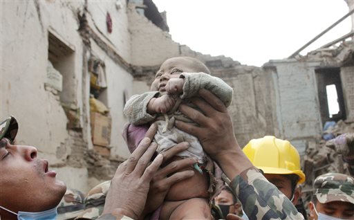 In this Sunday, April 26, 2015, photo taken by Amul Thapa and provided by KathmanduToday.com, four-month-old baby boy Sonit Awal is held up by Nepalese Army soldiers after being rescued from the rubble of his house in Bhaktapur, Nepal, after Saturday's 7.8-magnitude earthquake shook the densely populated Kathmandu valley.  Thapa says that when he saw the baby alive after 20 hours of rescue efforts  all my sorrow went. Everyone was clapping. It gave me energy and made me smile in spite of lots of pain hidden inside me." (Amul Thapa/KathmanduToday.com via AP)