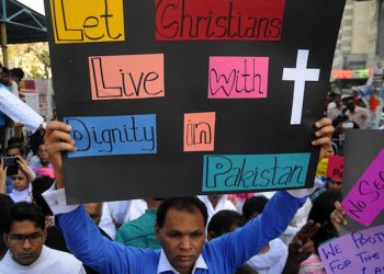 epa04664803 A Pakistani Christian man holds a banner during a protest one day after Lahore churches attack, in Karachi, Pakistan, 16 March 2015. Thousands of Christians across Pakistan on 16 March mourned 15 people killed by suicide bombers at Mass the day before, in the latest attack against religious minorities in the country. The bombings occurred in Yohana Abad locality of eastern Lahore city, sparking violent protests by members of Christian community, who later burnt alive two people they accused of aiding the two bombers.  EPA/SHAHZAIB AKBER