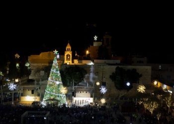 Palestinian Christians celebrate the lighting of a Christmas tree in Manger Square, outside the Church of the Nativity in the West Bank town of Bethlehem, Saturday, Dec. 5, 2015. Christmas Eve is a major event for the biblical town, drawing thousands of foreign tourists each year and giving a huge jolt to local businesses. This year, the holiday spirit will be harder to find as weeks of Israeli-Palestinian violence dampens the Christmas spirit. (AP Photo/Majdi Mohammed)