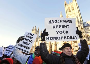 Human rights campaigner Peter Tatchell, right, demonstrates with others against the decision by Anglican Primates to punish pro-gay equality churches in North America, in front of the Canterbury Cathedral in Canterbury, England, Friday, Jan. 15, 2016. Anglican spiritual leader Justin Welby is set to lead a task force that will focus on rebuilding relationships after religious leaders temporarily restricted the role of the Episcopal Church in their global fellowship as a sanction over the U.S. church's acceptance of gay marriage. Welby, the Archbishop of Canterbury, is expected Friday to explain the decision to bar Episcopalians from any policy-setting positions in the Anglican Communion for three years. The decision avoided a permanent split in the 85 million-member communion, though it dismayed liberal Anglicans. (AP Photo/Frank Augstein)
