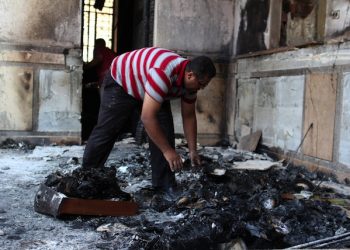 epa03825673 An Egyptian man cleans the floor from charred objects inside the Prince Tadros church which was set to fire overnight in Minya, about 245 kilometers south of Cairo, Egypt, 15 August 2013. Egyptian government has said that 522 people were killed in the country on 14 August in violence linked to the police's break-up of major protest camps by Islamists in Cairo. Spokesman Mohammed Fatallah said that the figure included 289 killed in the crackdown on the two pro-Morsi protest vigils in the north-east and south of the capital.  EPA/GIRO MAIS