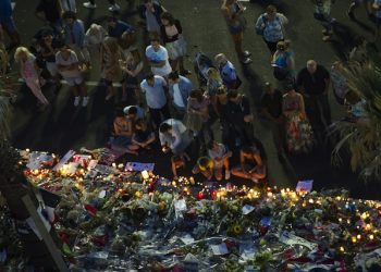 epa05429790 People gather at a makeshift memorial of flowers and candles on the 'Promenade des Anglais' where the truck crashed into the crowd during the Bastille Day celebrations, in Nice, France, 17 July 2016. According to reports, at least 84 people died and many were wounded after a truck drove into the crowd on the famous Promenade des Anglais during celebrations of Bastille Day in Nice, late 14 July.  EPA/OLIVIER ANRIGO