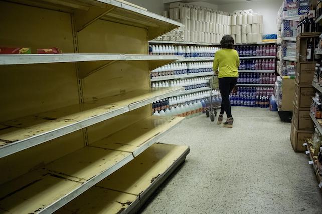 epa05155581 A woman shops in a supermarket in Caracas, Venezuela, 11 February 2016. Venezuelan Parliament has declared the 'National food crisis' and called the UN agencies FAO and Uniced to assess the risk of scarcity in the Venezuelan population.  EPA/MIGUEL GUTIERREZ