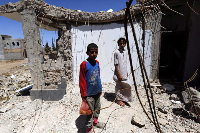 Bambini fra edifici bombardati dai sauditi in Yemen
