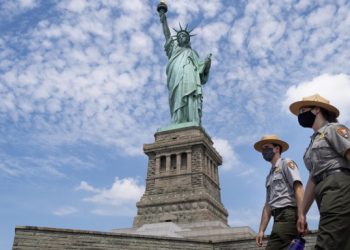 Agenti di sicurezza sorvegliano la statua della libertà a New York durante l'emergenza coronavirus