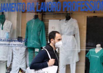 Esposizione di camici e abbigliamento per medici e infermieri in una vetrina di negozio