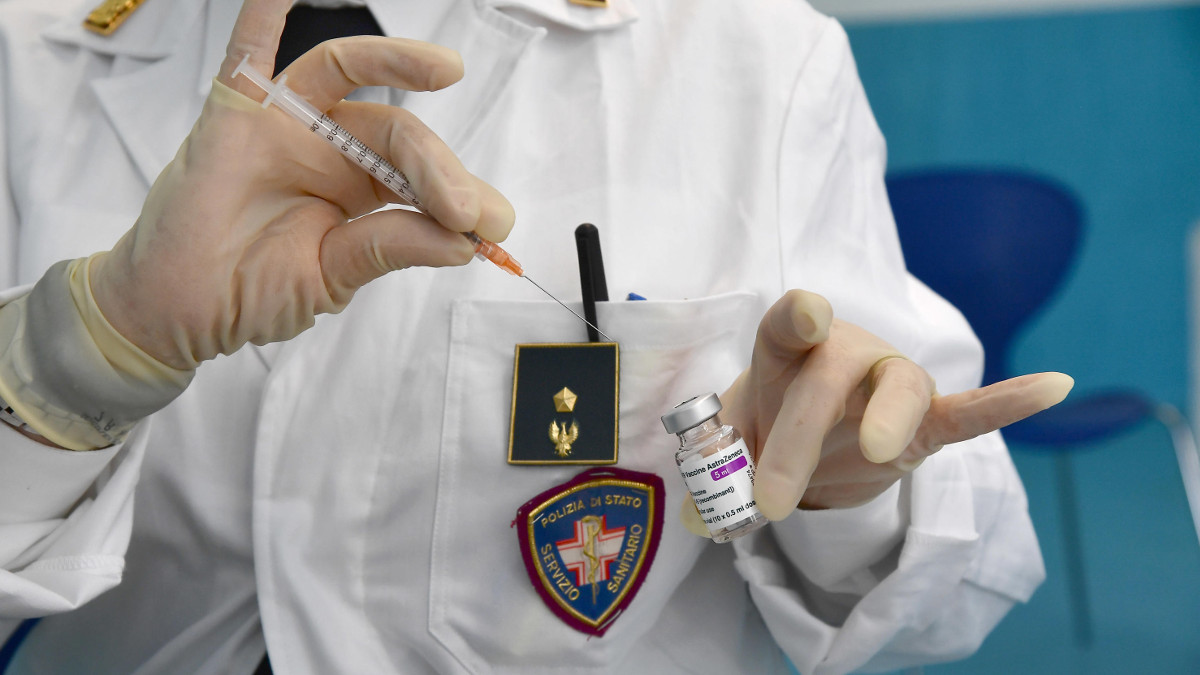 Agente di polizia somministra vaccino AstraZeneca