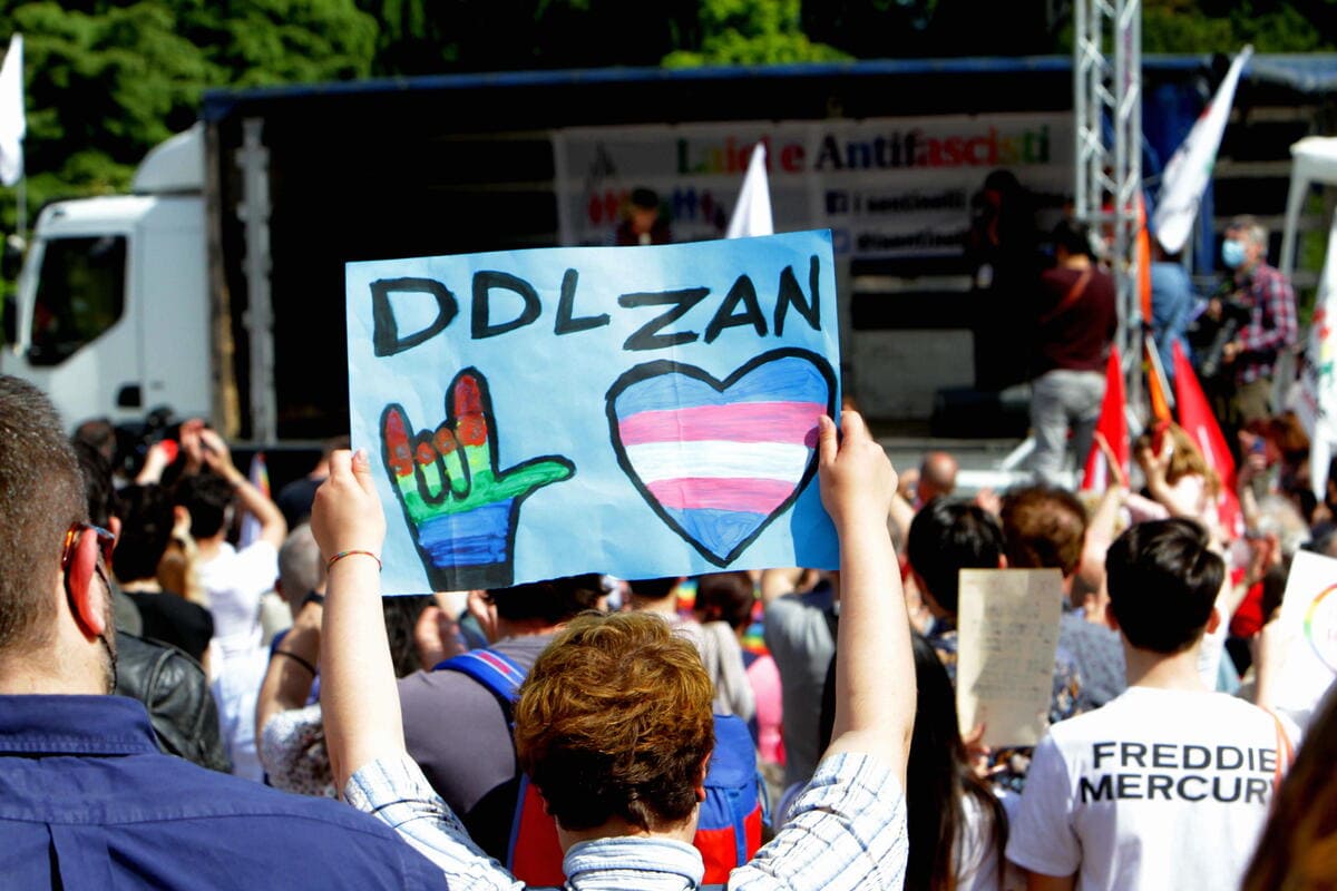 Manifestazione a Milano, un uomo alza un cartello pro ddl Zan