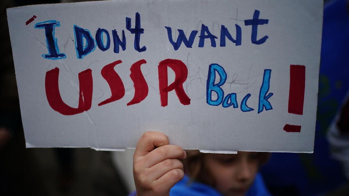 Uno dei cartelli agitati davanti all’ambasciata russa a Berlino