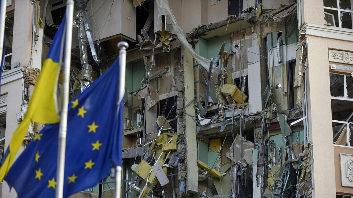 Bandiere di Ucraina e Unione Europea sventolano a Kiev di fianco a un edificio danneggiato dai missili russi