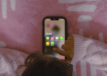 Una bambina gioca con uno smartphone