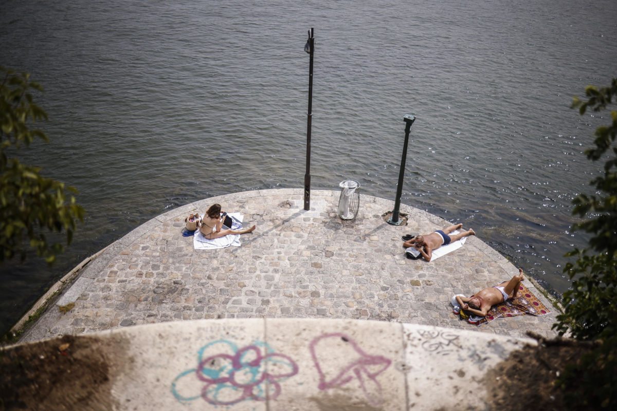 Parigini in costume da bagno cercano refrigerio dall’ondata di caldo estivo sulle rive della Senna