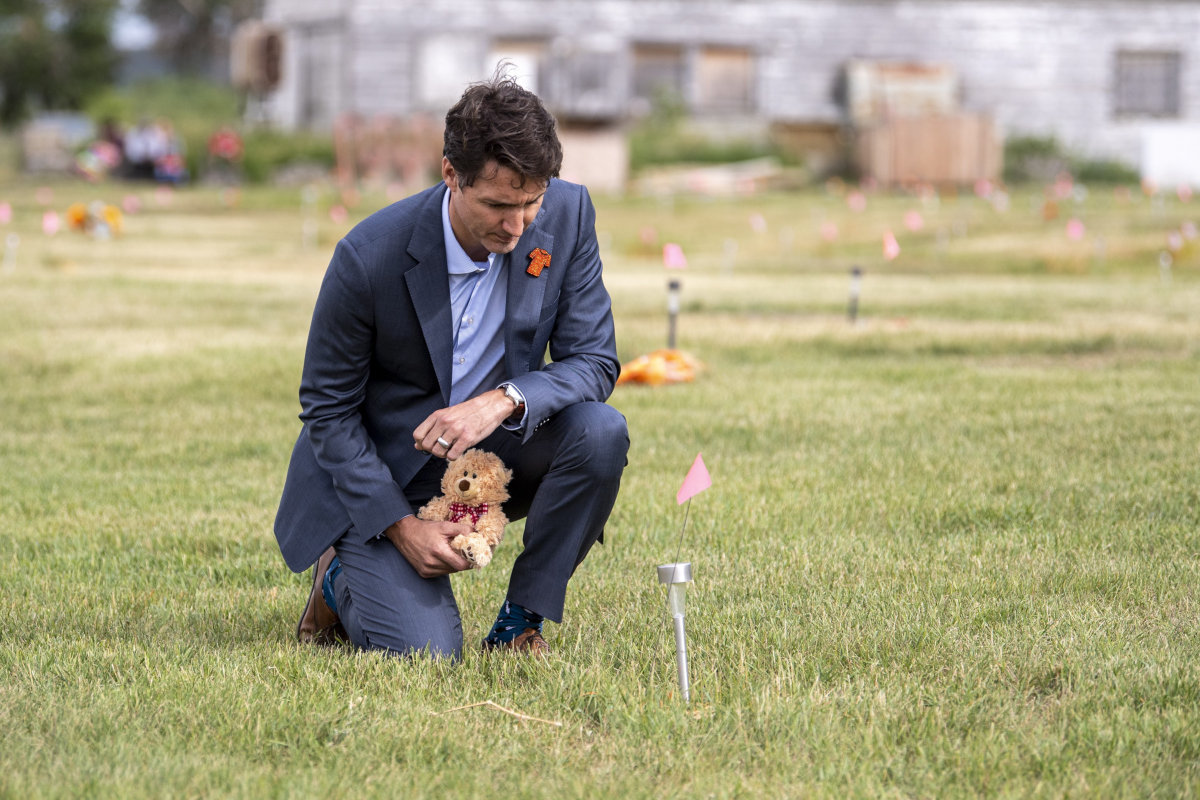 Il primo ministro canadese Justin Trudeau con un orsacchiotto di peluche sul luogo della presunta fossa comune di bambini indigeni individuata nei pressi di una scuola residenziale nella riserva di Cowessess, 6 luglio 2021