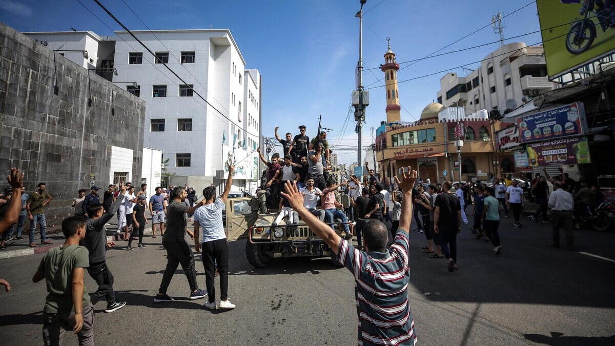 Palestinesi a bordo di una jeep militare israeliana per le strade di Gaza durante l'assalto agli insediamenti israeliani da parte di Hamas