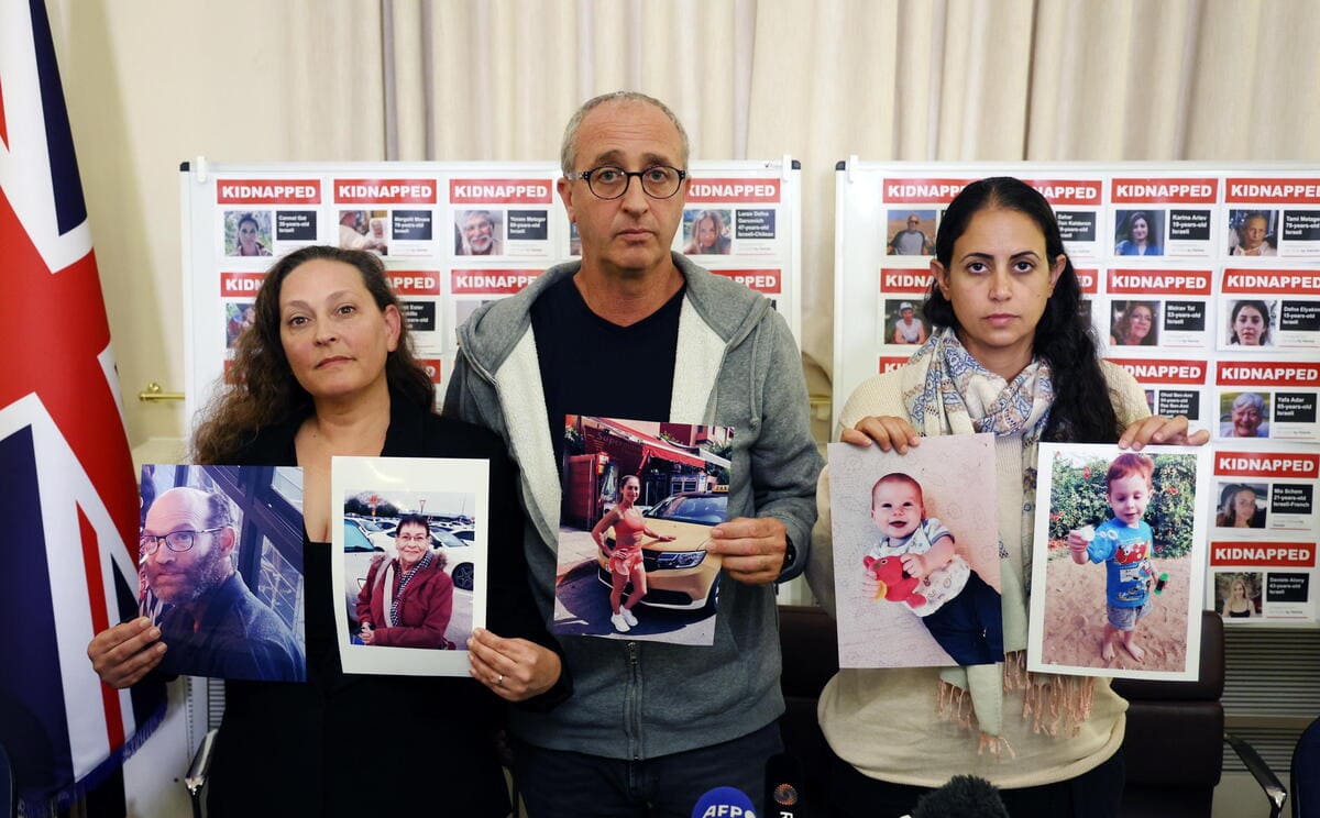 Parenti degli ostaggi israeliani, tengono fotografie dei propri cari e delle vittime di Hamas, il 24 ottobre 2023 (Ansa)