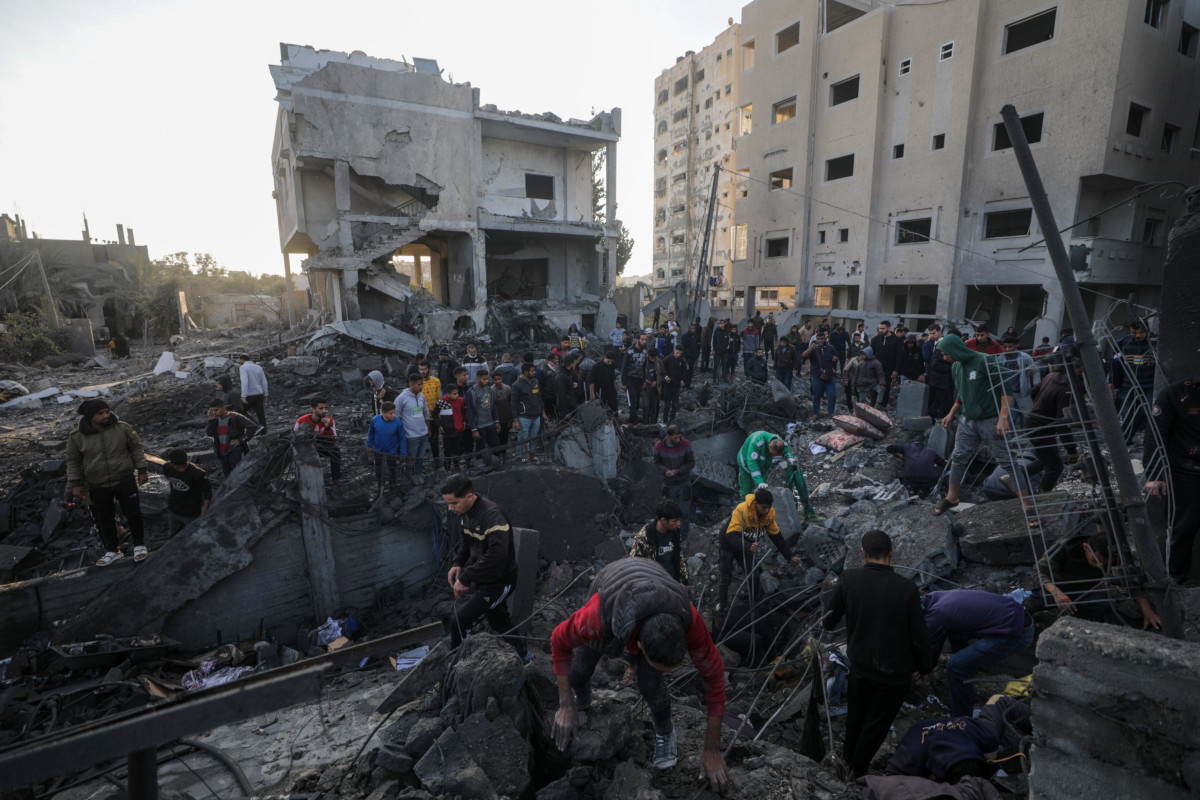 Palestinesi in cerca di sopravvissuti tra le macerie dopo un bombardamento israeliano ad Al Nusairat, nella Striscia di Gaza, 20 febbraio 2024