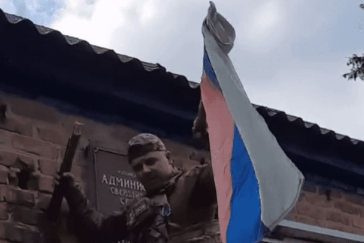 Un soldato ucraino sostituisce la bandiera russa con quella ucraina a Sverdlikovo, nella regione russa di Kursk
