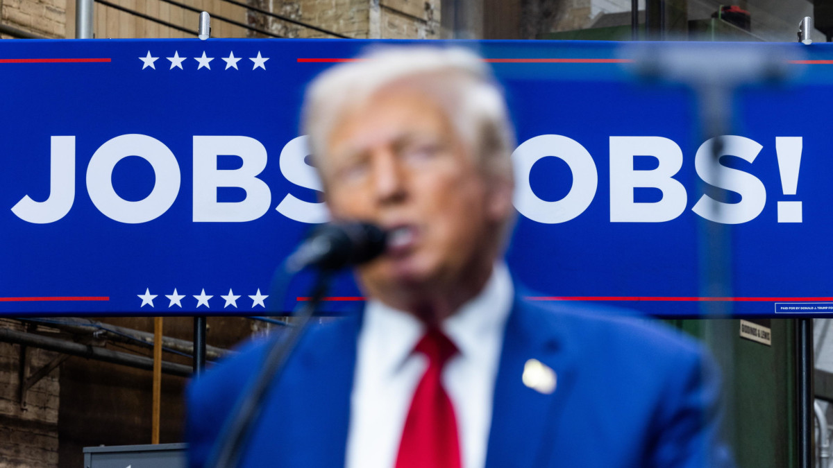 Il candidato dei repubblicani alla presidenza Usa Donald Trump durante un comizio elettorale a York, Pennsylvania. Alle sue spalle un manifesto promette posti di lavoro (foto Ansa)
